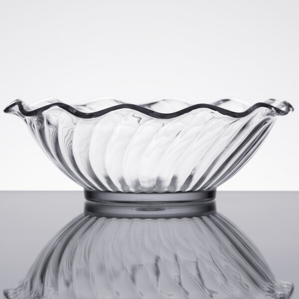 A close up of a Carlisle clear glass bowl with a wavy edge.