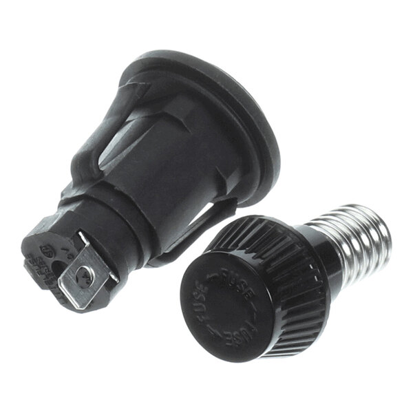 Two black cylindrical components, one with a metal spring and screw cap labeled 'FUSE,' and the other with metal terminals, likely parts of an electrical fuse holder.