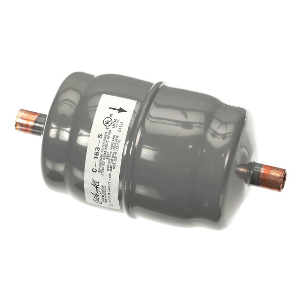 A cylindrical metal component with copper pipe fittings on both ends and a white label on the side.