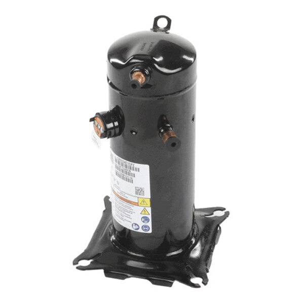 A black cylindrical metal component with two copper pipe fittings, a label with warnings and specifications, and a mounting base.
