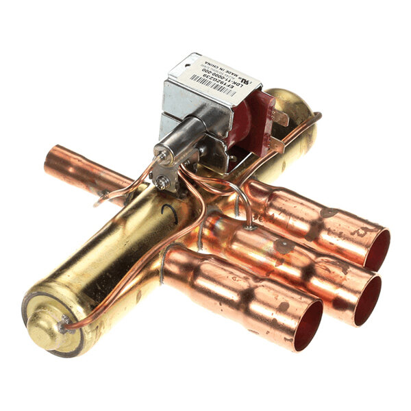 A metallic component with copper tubes and an attached solenoid, likely part of a refrigeration or HVAC system.