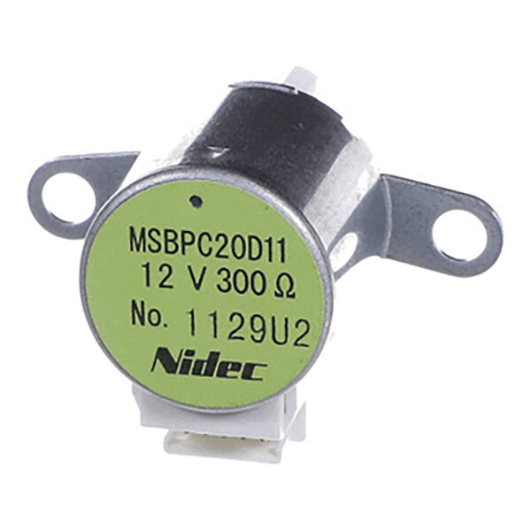 A small cylindrical metal component with two mounting flanges, a green label displaying specifications, and a white electrical connector at the bottom.
