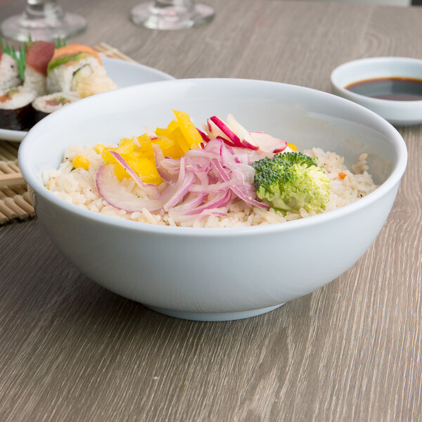A bowl of rice with vegetables in a Thunder Group Blue Jade melamine bowl.