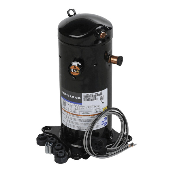 A black cylindrical mechanical component with copper pipe fittings, a label, and attached wires, mounted on a base with four feet.