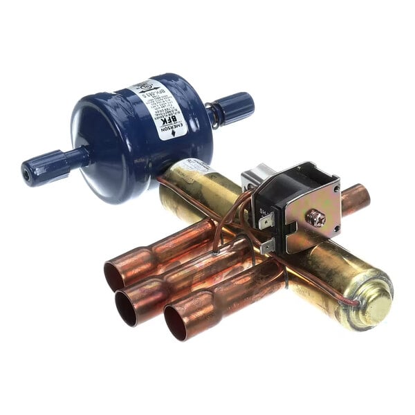 A metal component with copper pipes, a blue cylindrical filter, and an attached electrical part, likely part of an HVAC or refrigeration system.