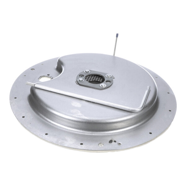 A round metallic plate with a raised center, multiple small holes around the edge, a mesh-covered opening in the middle secured by bolts, and a bent metal rod attached to the surface.