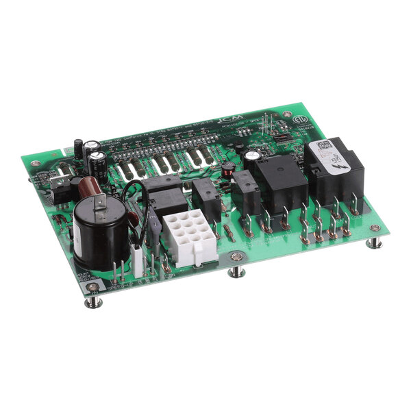 A green electronic circuit board with various components including capacitors, relays, connectors, and integrated circuits mounted on it.