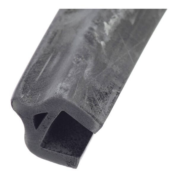 A close-up view of a black, rubber-like gasket with a hollow rectangular channel and an angled groove.
