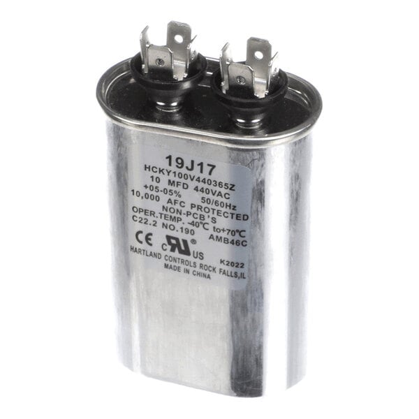 A metallic oval-shaped capacitor with two terminal connectors and a label displaying technical specifications.