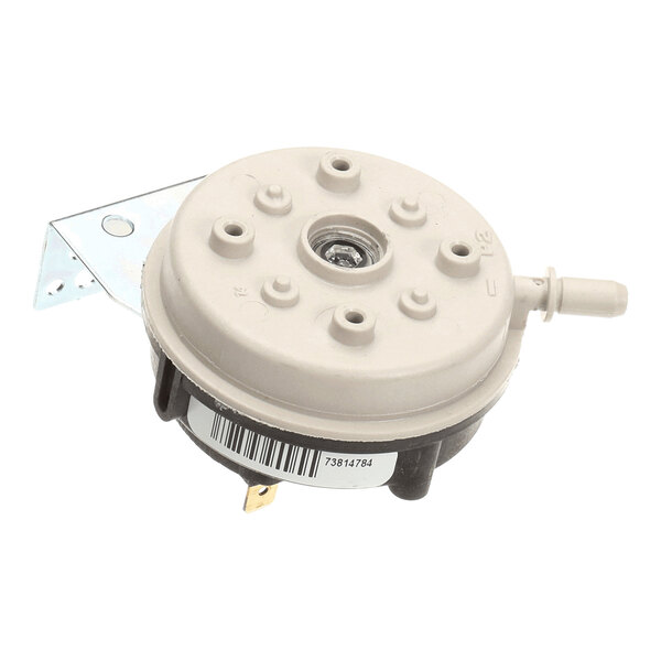 A round, beige and black mechanical component with a metal mounting bracket, electrical terminals, and a barcode label.