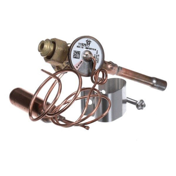A metallic component with coiled copper tubing, a cylindrical part, and a clamp with a screw, likely part of a mechanical or HVAC system.