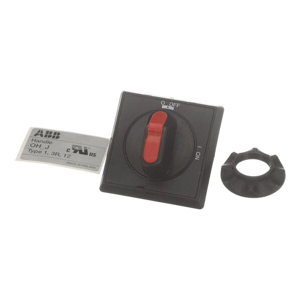 A black rotary switch with a red handle, a mounting ring, and a label placed beside it.