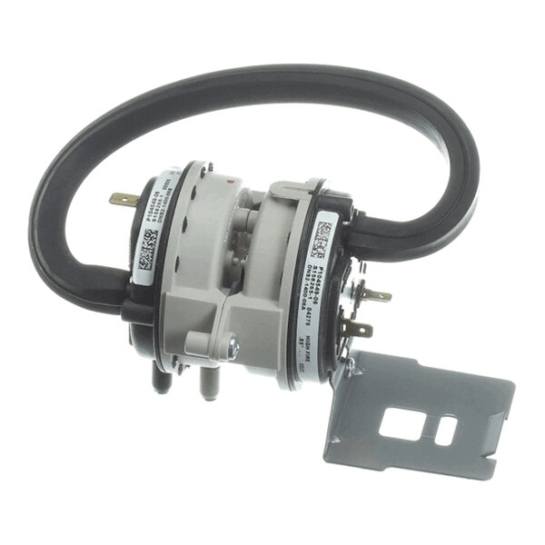 A round, dual-chambered mechanical device with attached wires, metal terminals, a flexible black tube, and a mounting bracket.