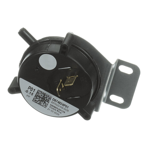 A round black component with two metal terminals, a mounting bracket, and a label with a QR code and technical information.