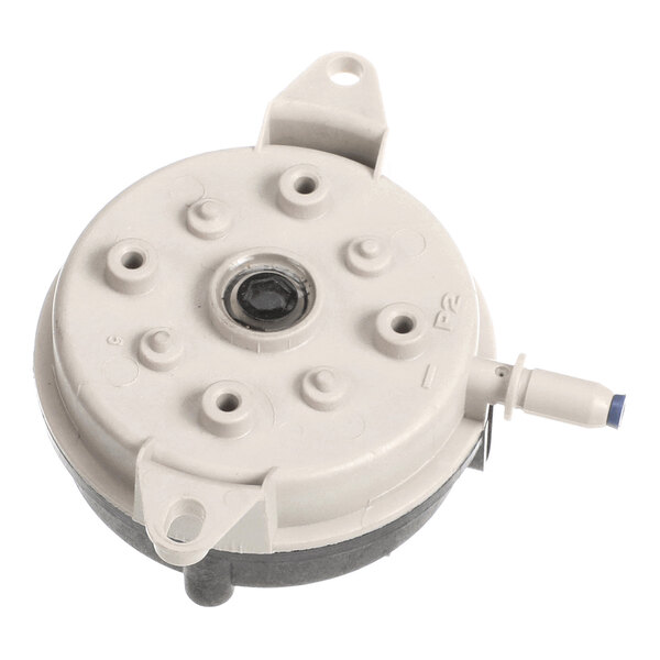 A round, gray plastic component with multiple raised circular features, a central hole, two mounting tabs, and a protruding nozzle on the side.