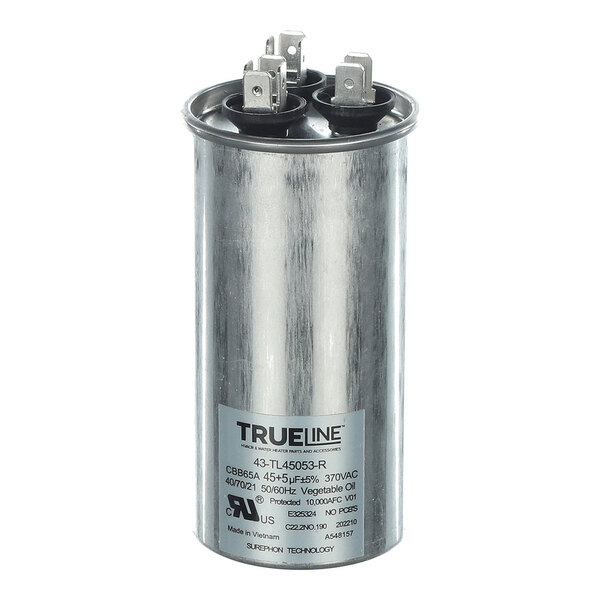A cylindrical metallic capacitor with three electrical terminals on top and a label displaying technical specifications.