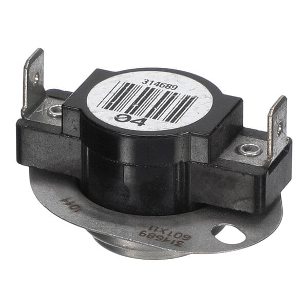 A close-up view of a round, black and metallic electrical component with two metal terminals and a barcode label on top.