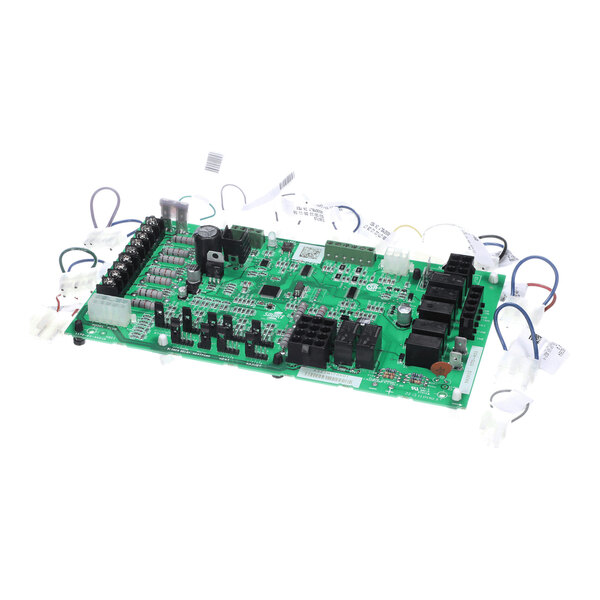 A green electronic circuit board with various components and attached wiring harnesses.