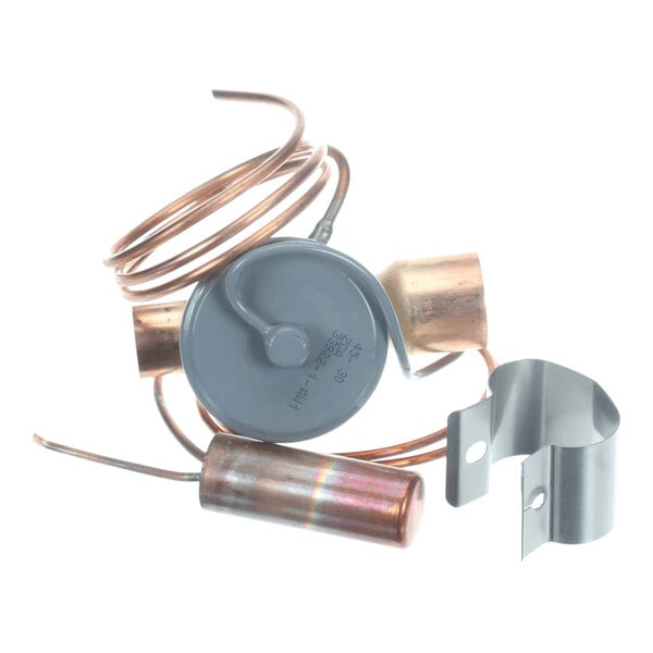 A coiled copper tube with attached metal components and a gray circular part, alongside a separate metal bracket.