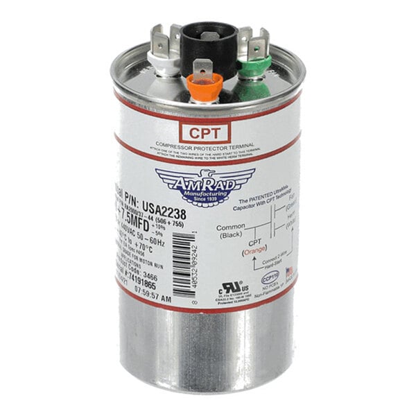 A cylindrical metal capacitor with three color-coded terminals (black, orange, and green) and a detailed label indicating specifications and wiring diagram.
