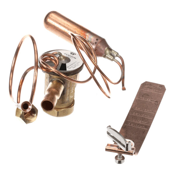 A set of copper and brass refrigeration components, including a valve with coiled tubing and a metal strip with an attached clamp, displayed on a white background.