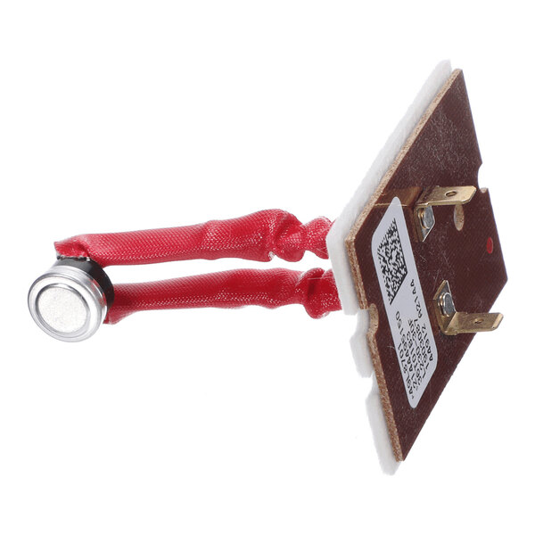 A small electronic component with two red insulated wires connected to a metal sensor and a brown rectangular mounting plate with metal terminals and a label.