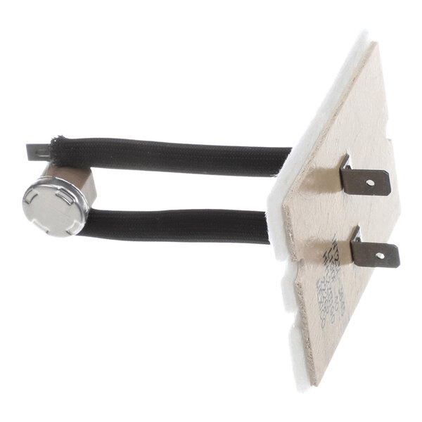 A small electronic component with two black wires connected to a metal cylindrical part and a rectangular board with two metal prongs.