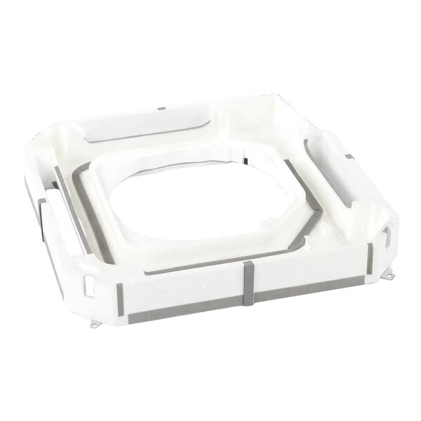 A white, square-shaped plastic component with raised edges and a central cutout, likely part of a larger assembly.