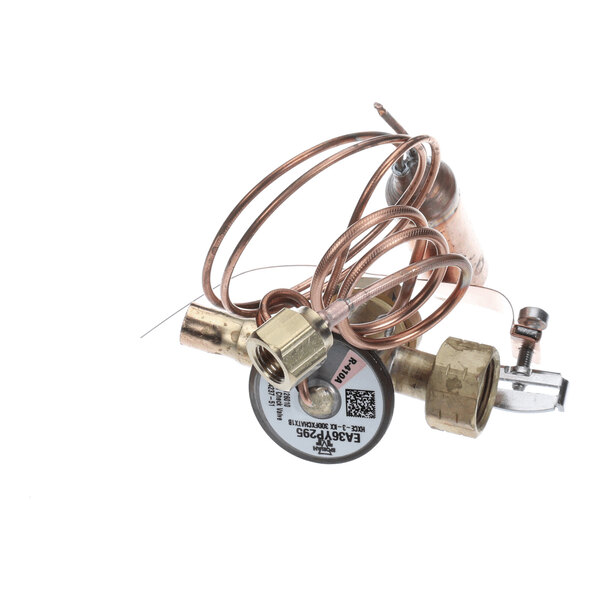 A coiled copper tube assembly with brass fittings and a labeled circular component, likely part of a refrigeration or HVAC system.