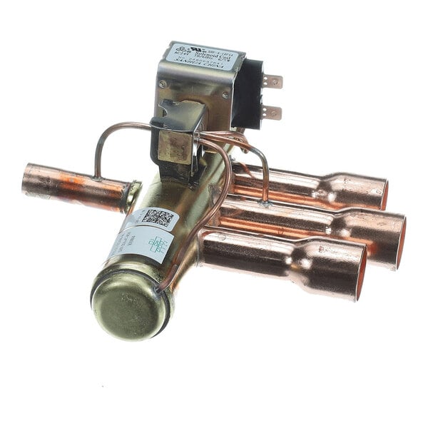 A metallic component with multiple copper tubes and an attached electrical solenoid, likely part of a refrigeration or HVAC system.