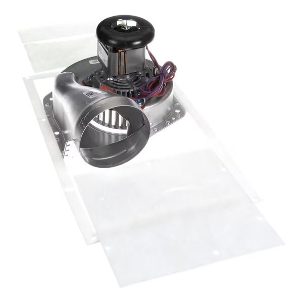 A metal blower assembly with a cylindrical fan, electric motor, and attached wiring, mounted on a flat base.