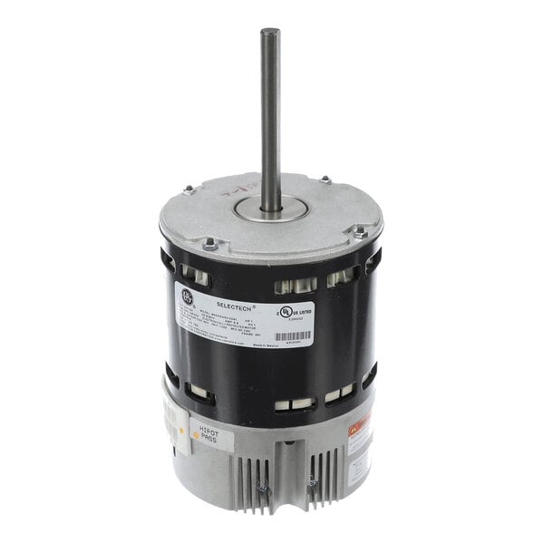 A cylindrical electric motor with a central shaft extending vertically from the top and a label with technical specifications on the side.