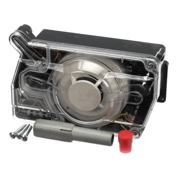 A transparent plastic-cased electronic device with a circular component inside, accompanied by three screws, a metal tube, and a red cap.