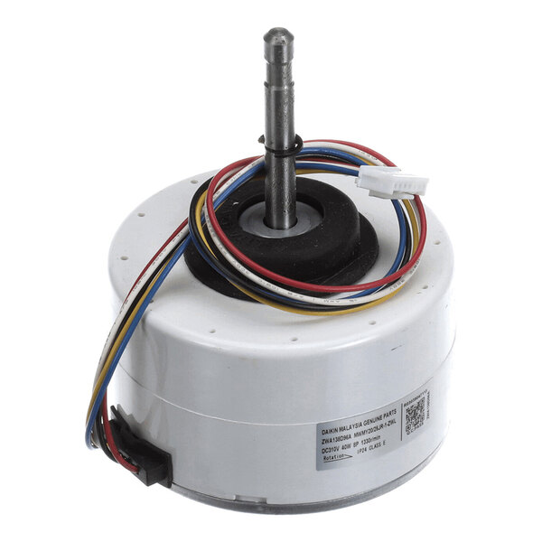A cylindrical electric motor with a central shaft, multiple colored wires, and a label on the side.