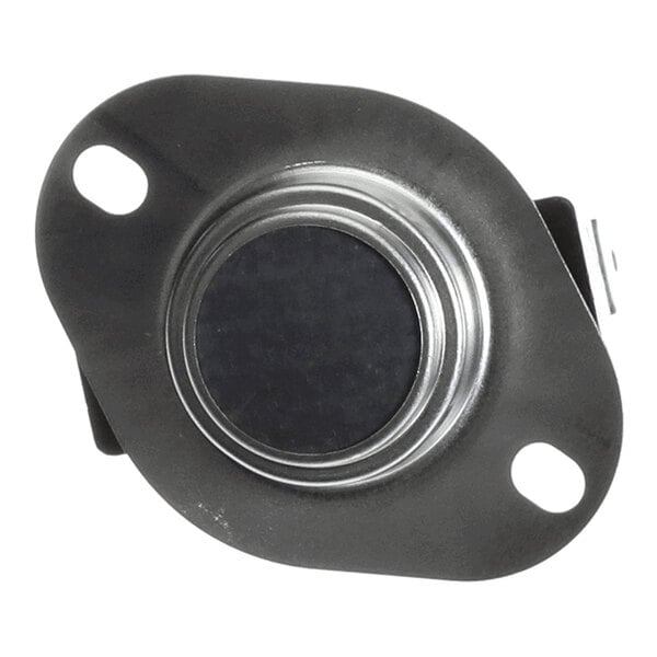A round metallic component with two mounting holes and a central black circular area, likely an electronic or mechanical switch or sensor.