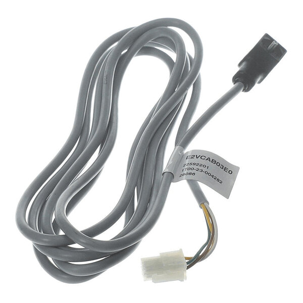 A coiled gray cable with connectors on both ends and a label attached to the wire.