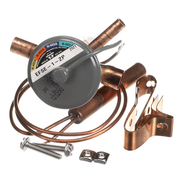A metal valve assembly with copper tubing, a mounting bracket, and screws, featuring a round gray component labeled with various refrigerant types.