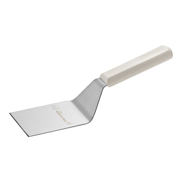 A white Dexter-Russell solid turner with a plastic handle.