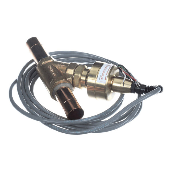 A brass valve with copper pipe fittings and an attached electrical cable, coiled around the device.