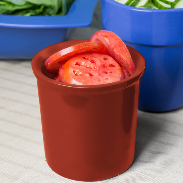 A Tablecraft copper condiment bowl filled with sliced tomatoes on a counter in a salad bar.