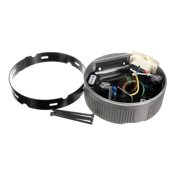 A round electronic module with visible internal components, a separate black mounting ring, and three screws placed beside it.