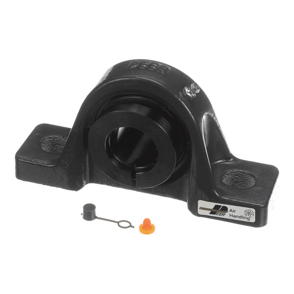 A black metal mounted bearing unit with two small plastic caps placed in front of it.