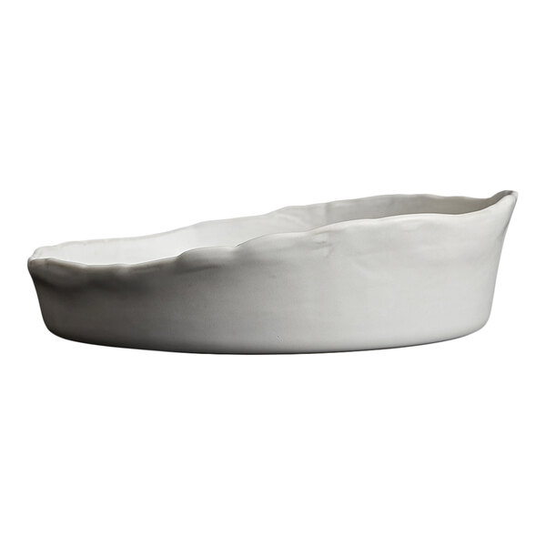 A white, round stoneware plate with an irregular, wavy rim and a deep, bowl-like shape.