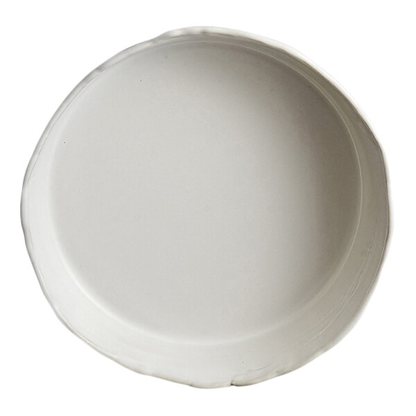 A round, white plate with a slightly irregular rim and a smooth surface.