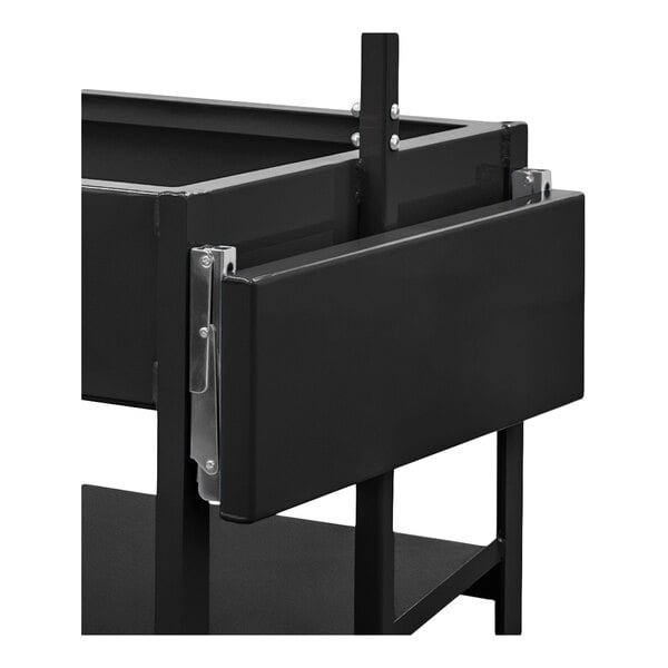 A close-up view of a black metal folding shelf attached to a larger frame structure.