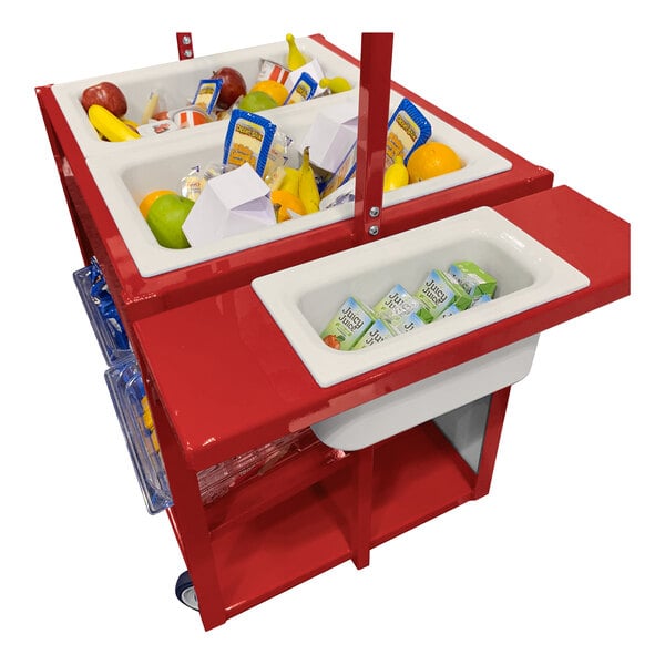 A red cart with multiple white bins containing assorted fruits, packaged snacks, and juice boxes.
