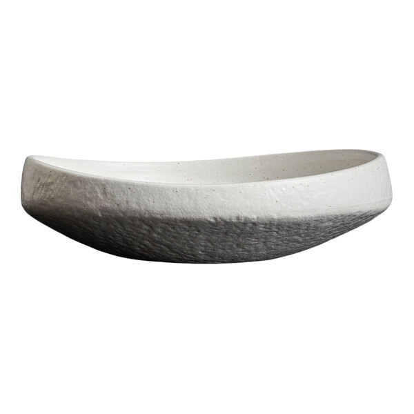A shallow, oval-shaped plate with a textured, two-tone finish featuring a white upper half and a darker, rougher lower half.
