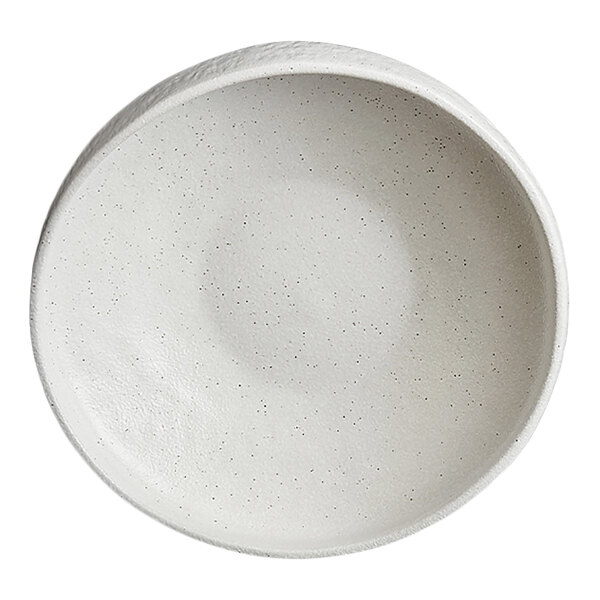 A round, white, stoneware plate with a slightly textured and speckled surface.