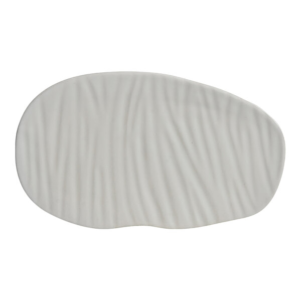 An irregularly shaped white plate with a subtle wavy textured surface.