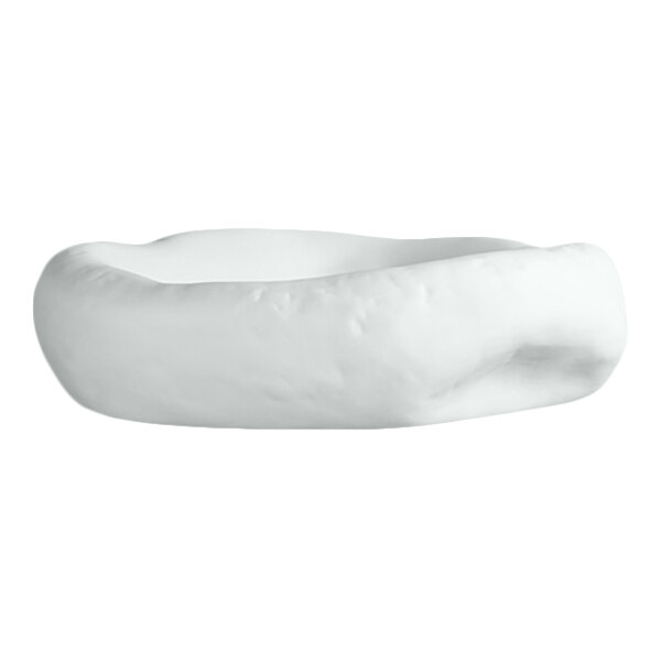 A white, round porcelain dish with an irregular, organic-shaped rim and a smooth matte finish.